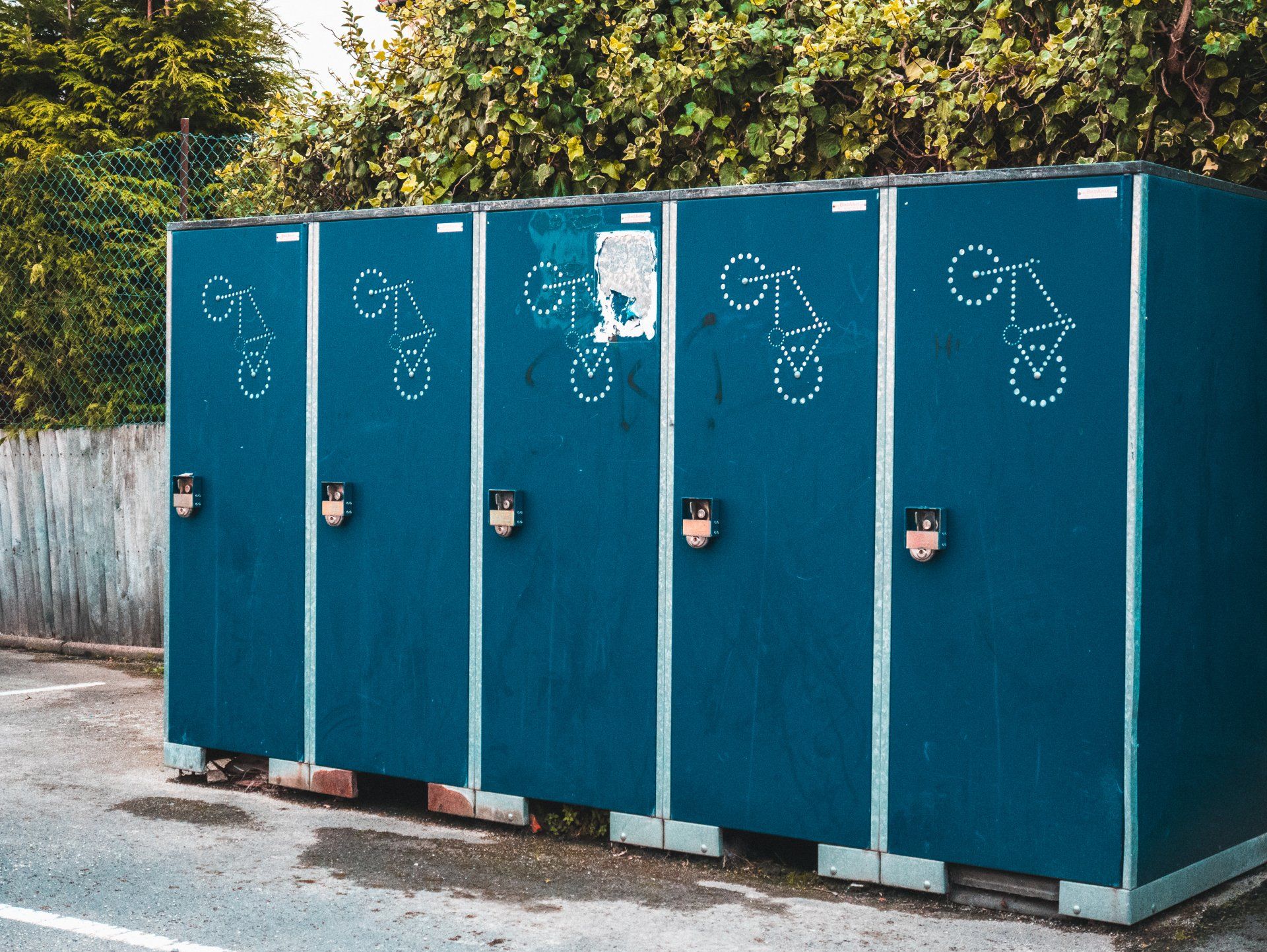 a green dumpster and a green portable toilet are parked next to each other .