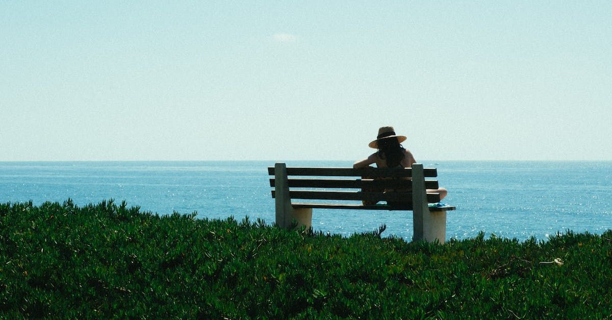 Donna seduta su una panchina che guarda il mare