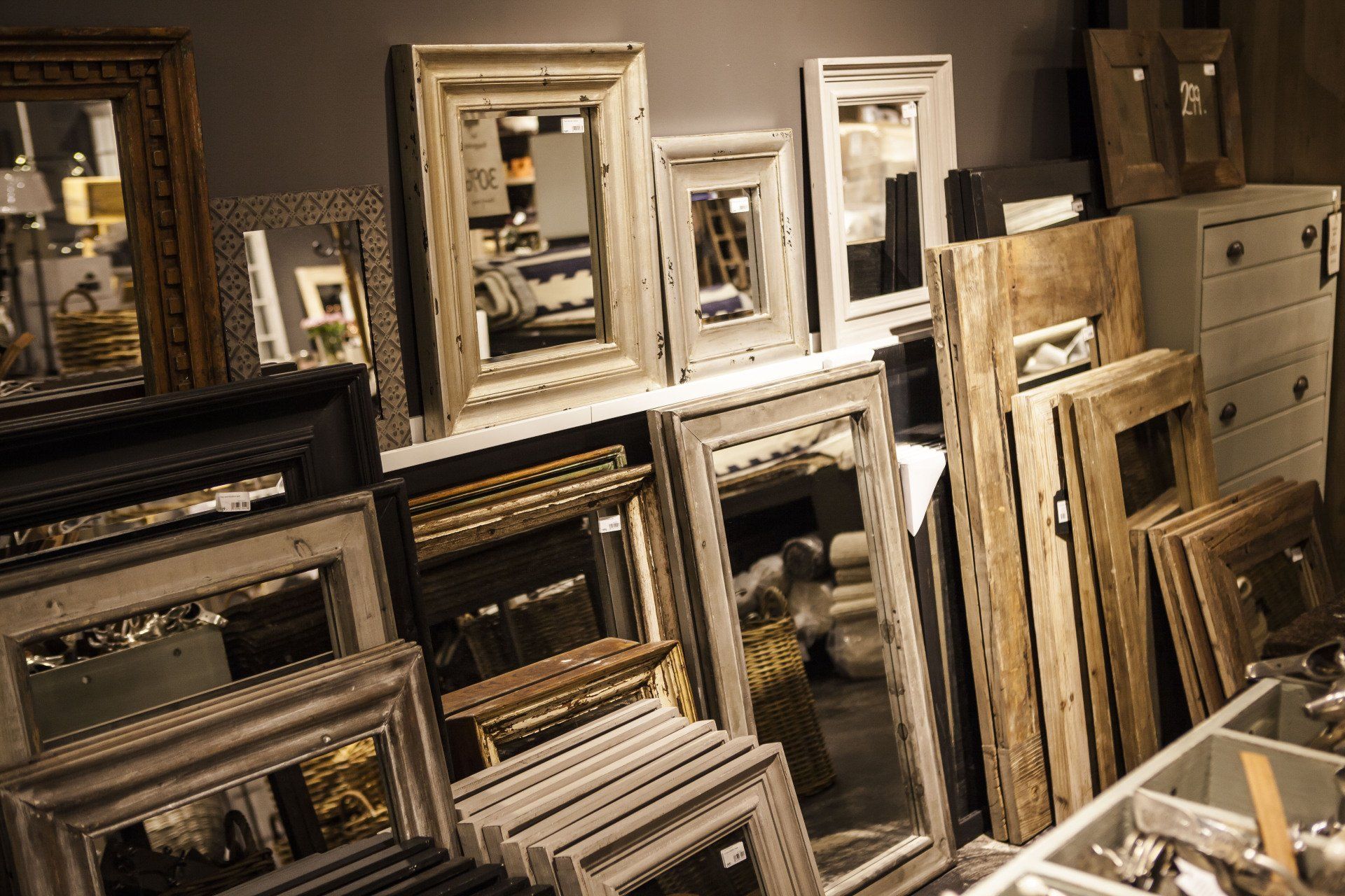 A bunch of mirrors are stacked on top of each other in a room.