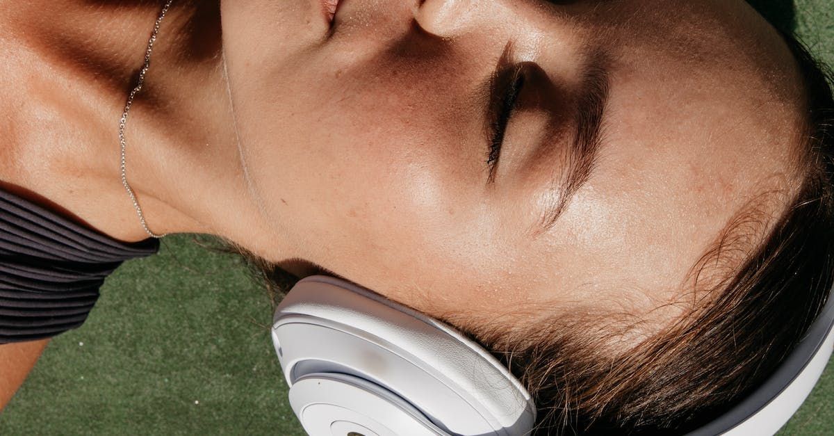 A woman wearing headphones is sitting at a table listening to Safe and Sound Protocol.