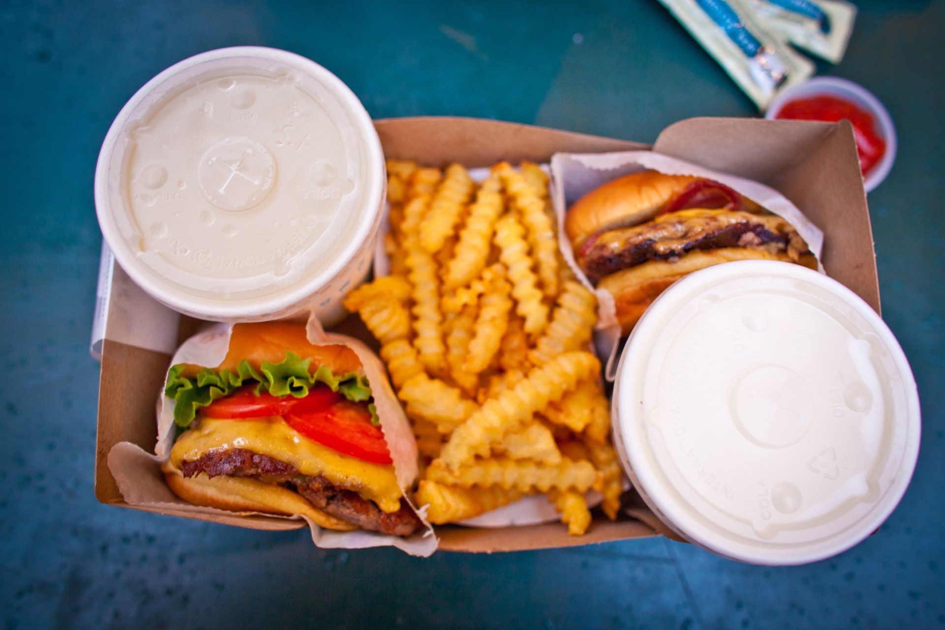 A cardboard box filled with hamburgers and french fries