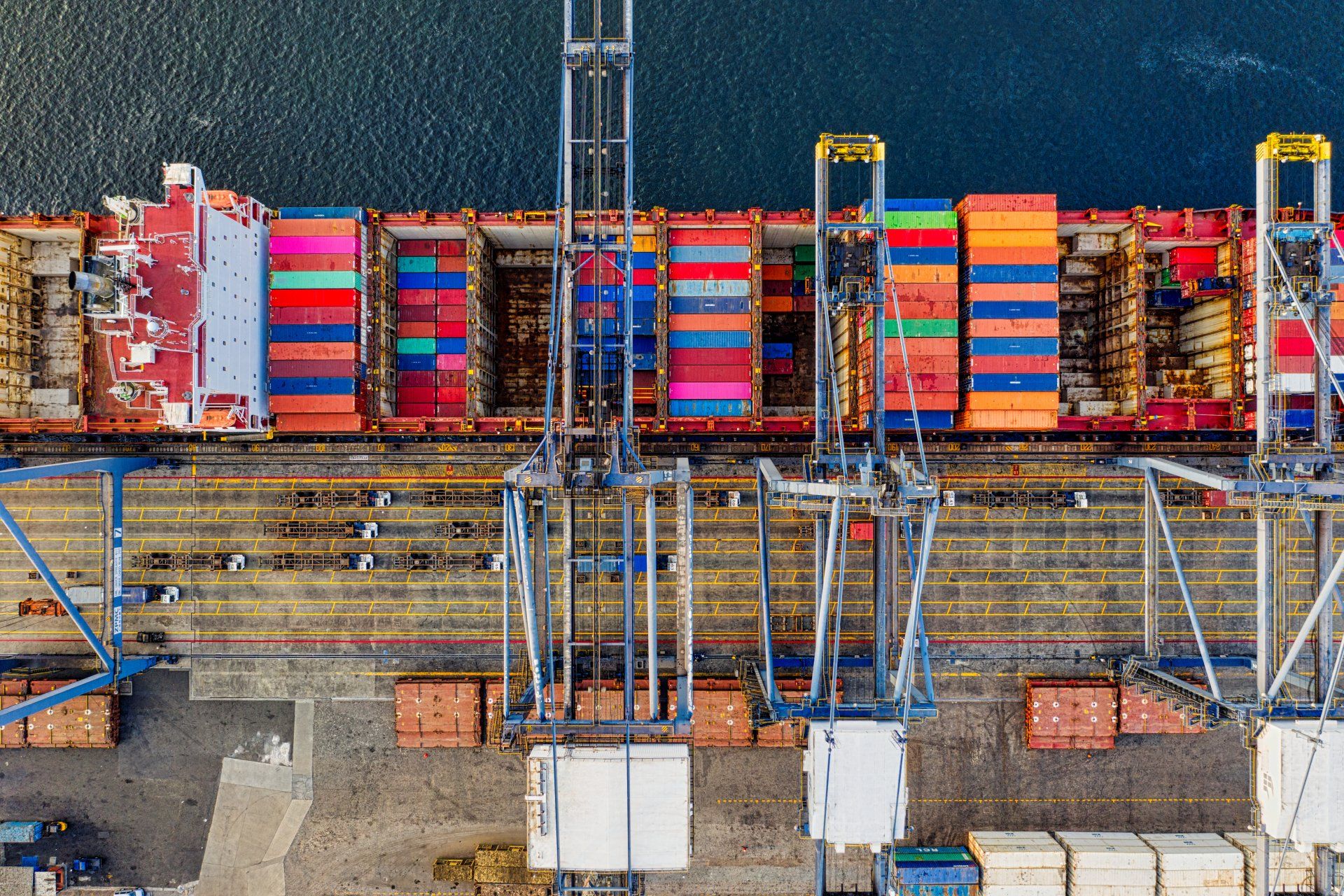An aerial view of a large container ship docked at a port.