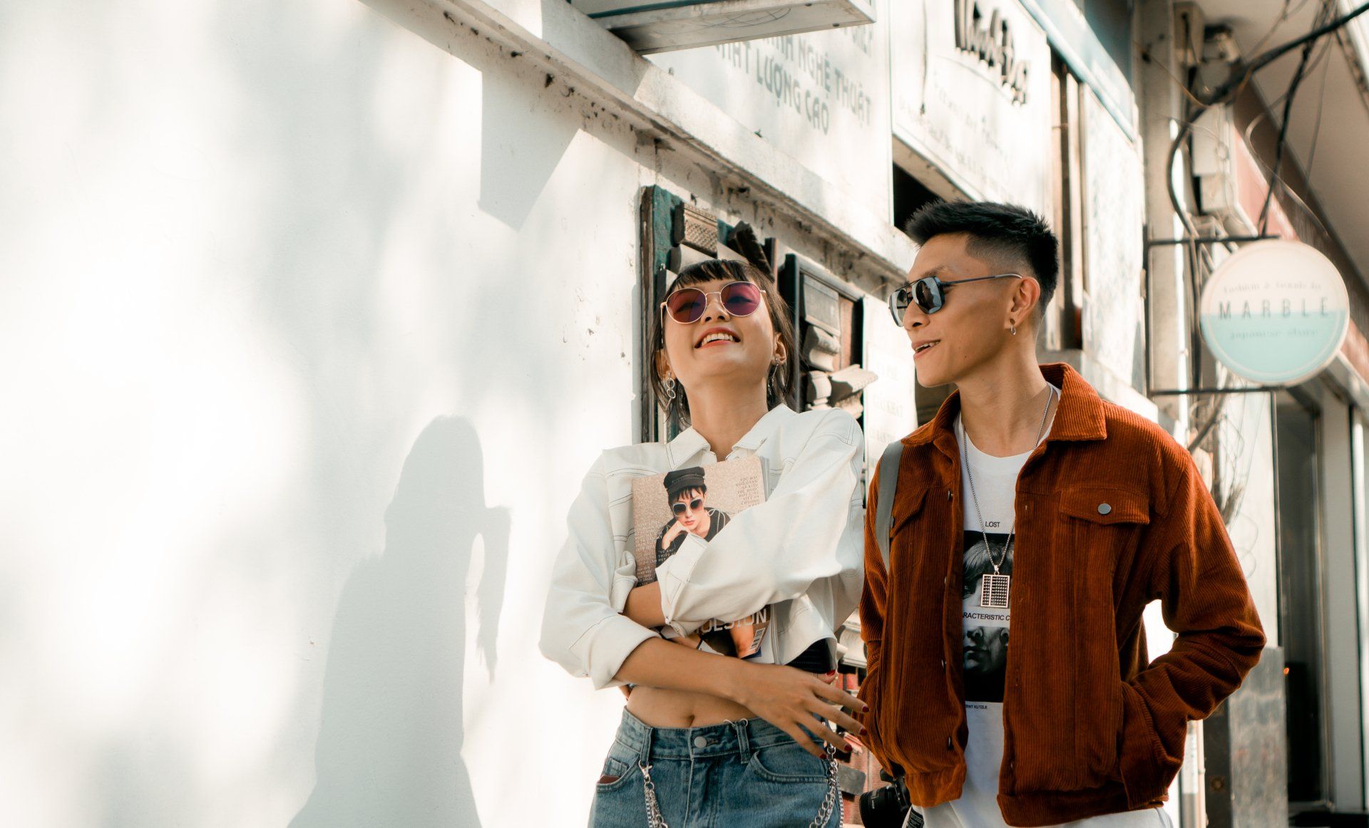 A man and a woman are standing next to each other on a sidewalk.
