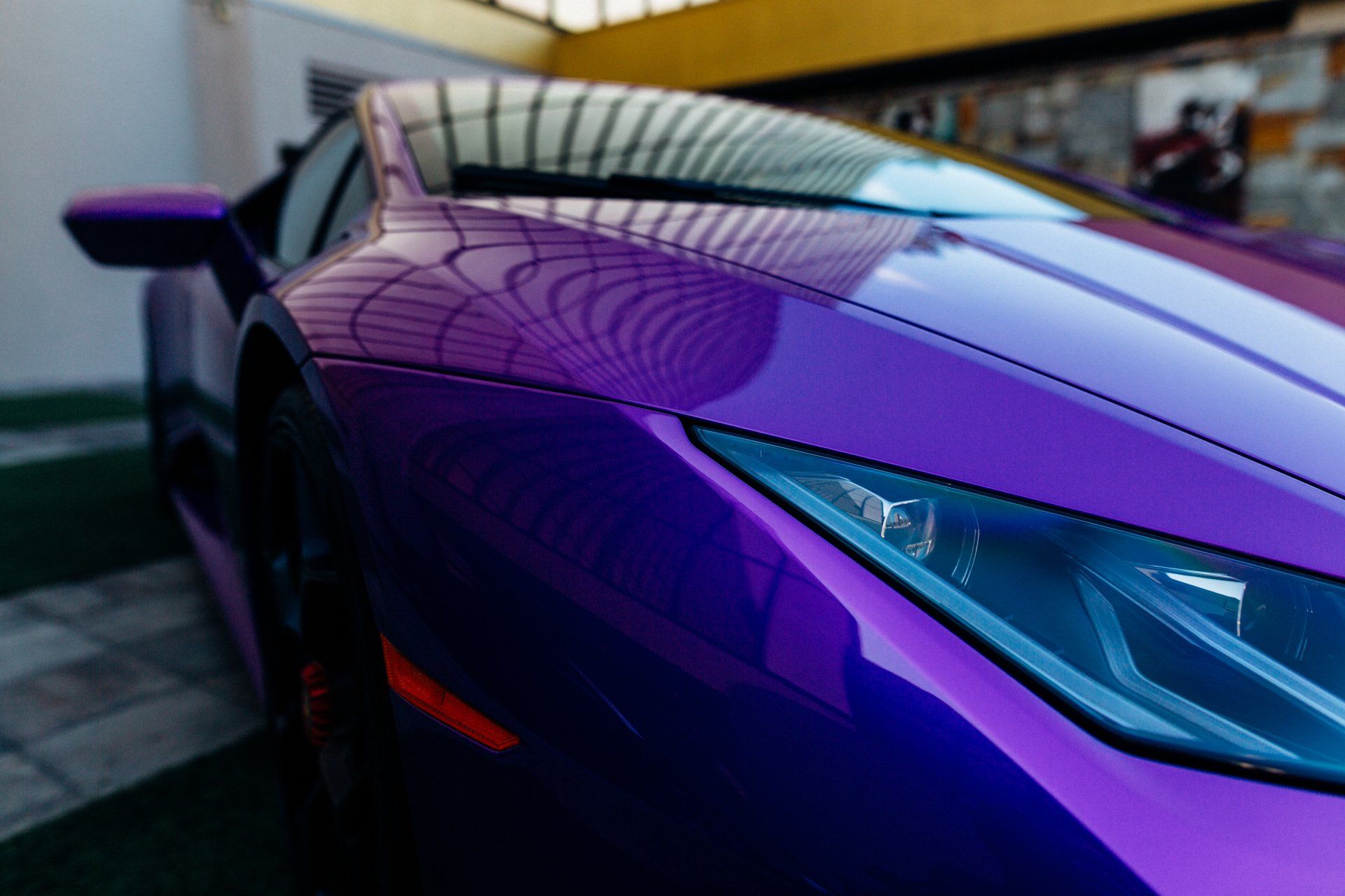 A close up of a purple sports car parked in a parking lot.
