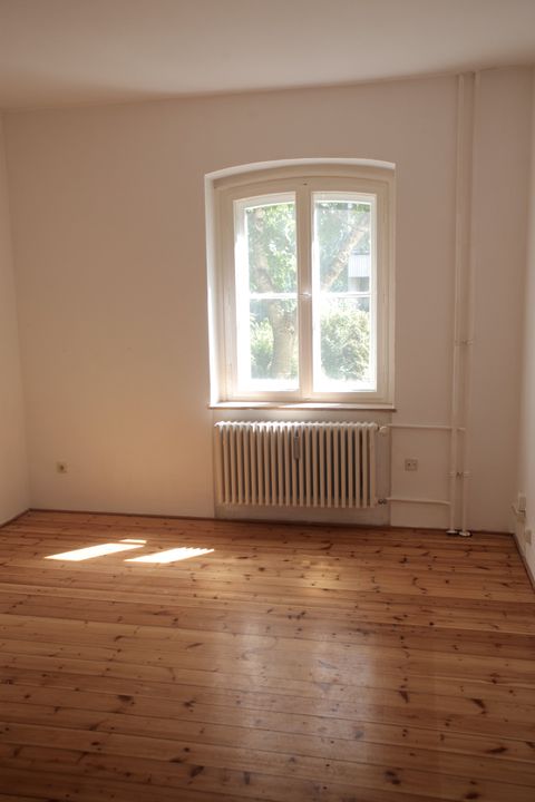 An empty room with a radiator and a window