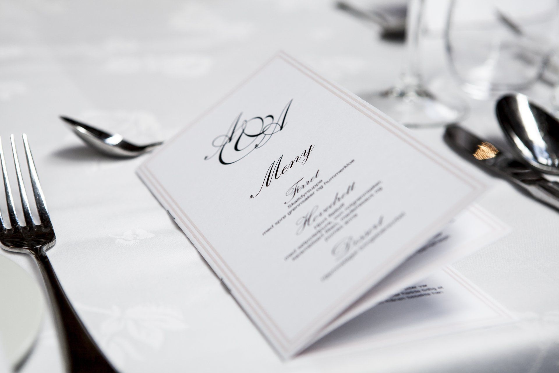 A menu is sitting on a table with silverware