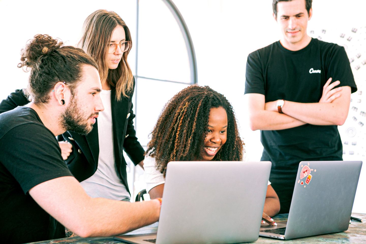 A group of people are looking at a laptop computer.