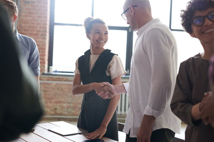 A group of people are shaking hands in a room.