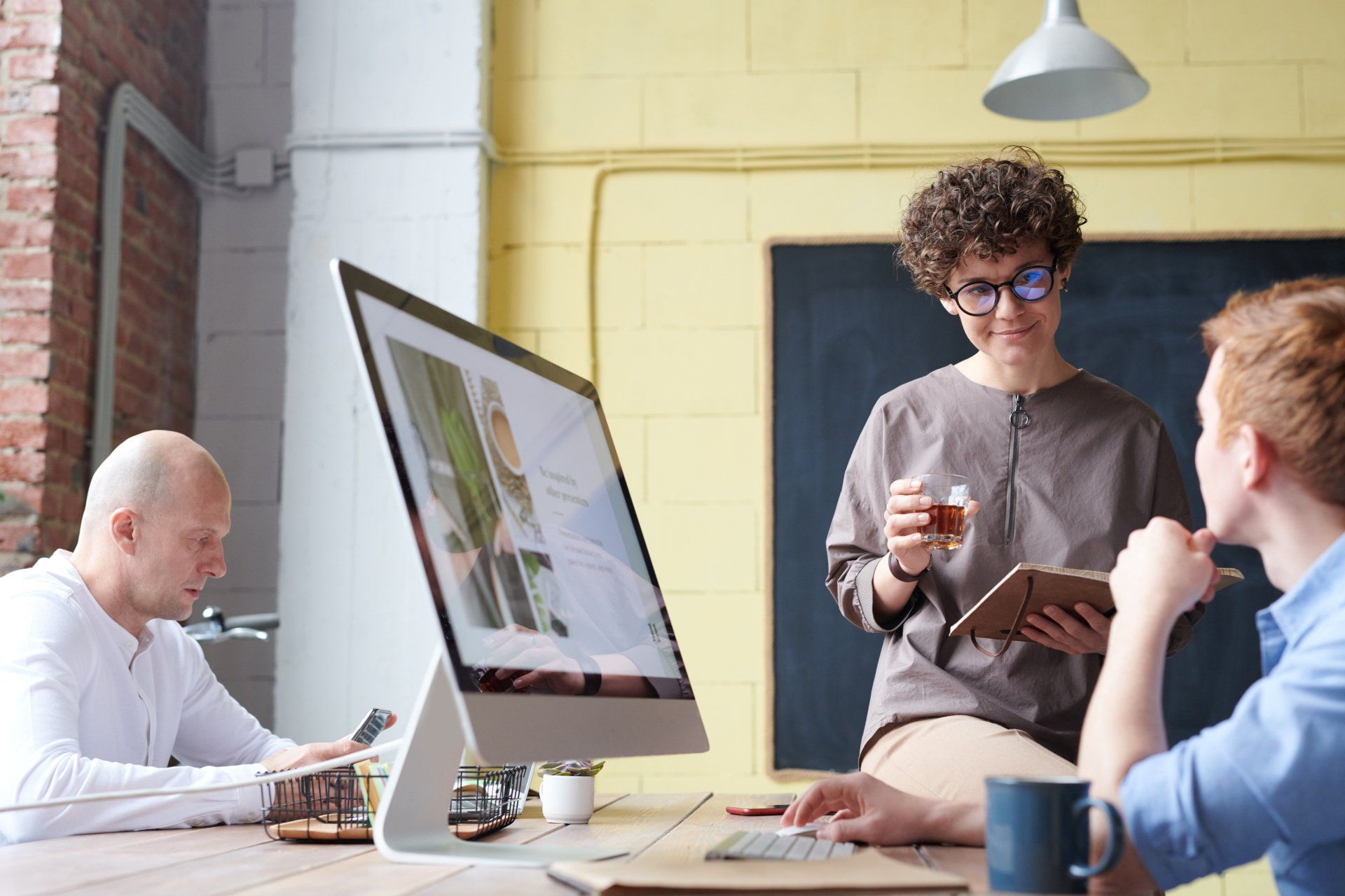 A group of people are sitting at a table in front of a computer.