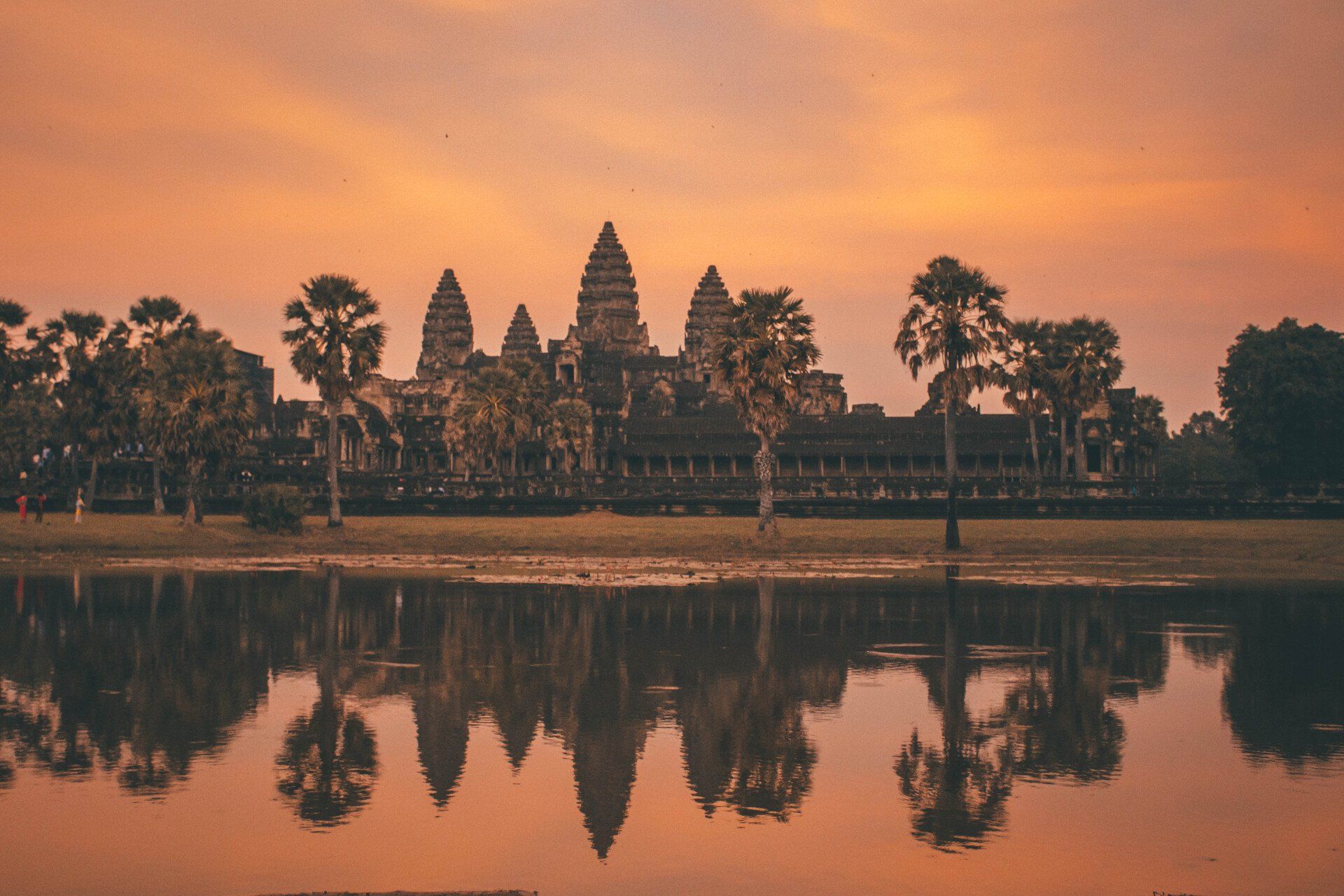 The temple is reflected in the water at sunset.