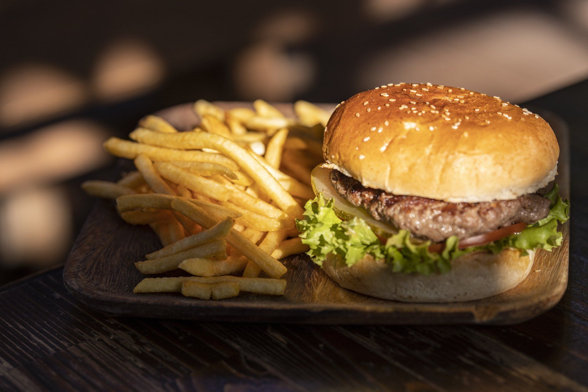 Dining in Milton, NZ - a hamburger and french fries on a wooden plate