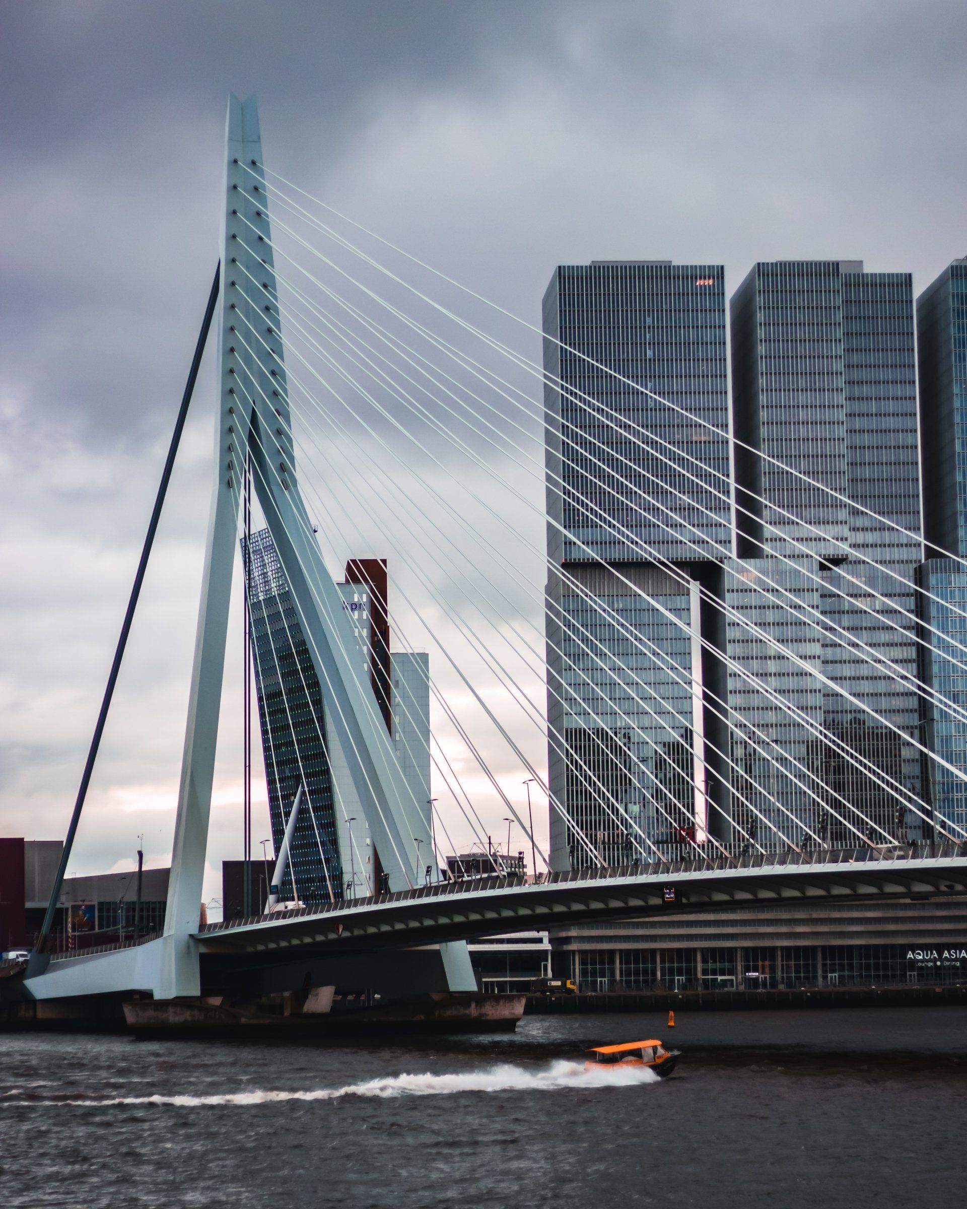A bridge over a body of water with tall buildings in the background