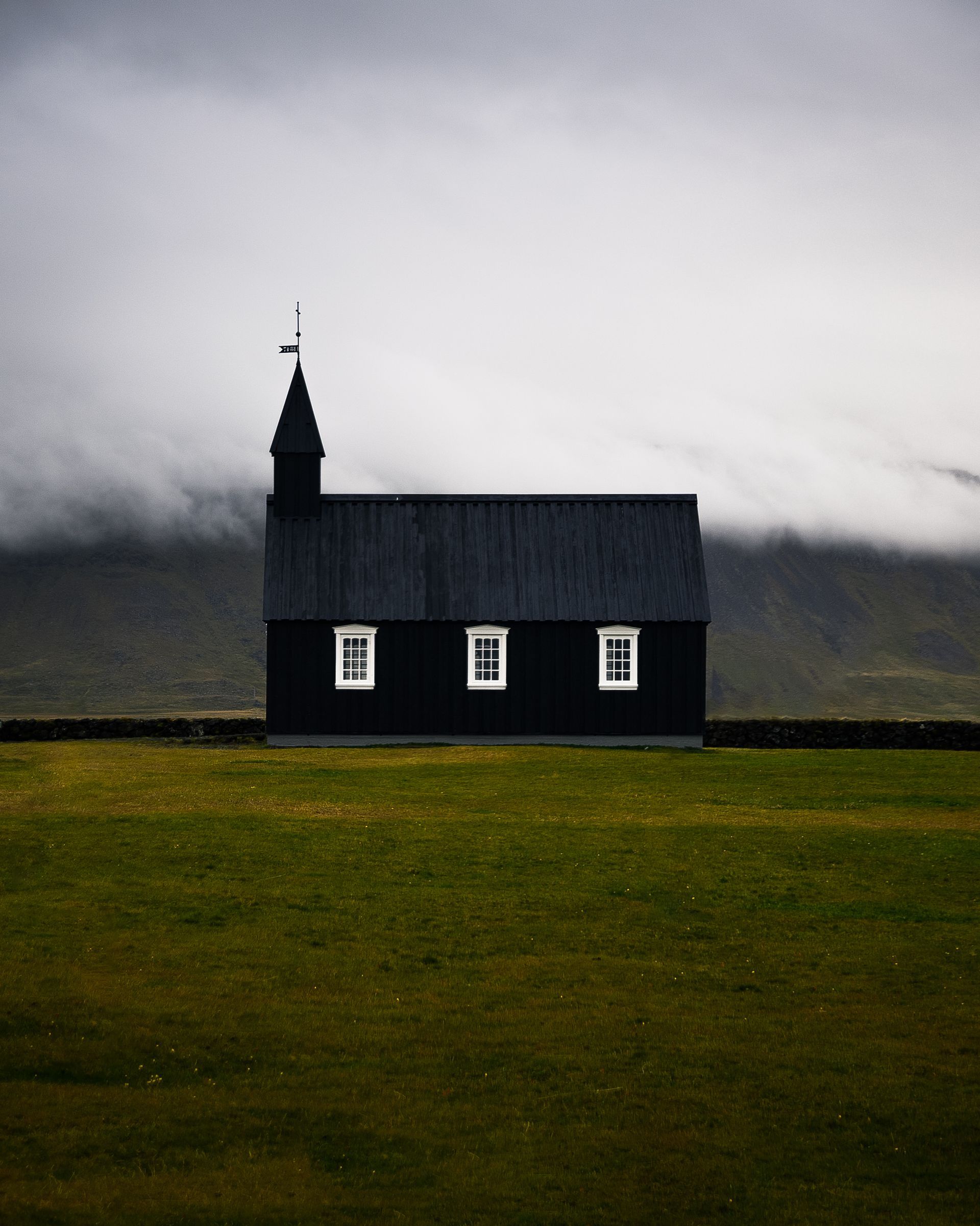 svart kyrka i ett kargt landskap