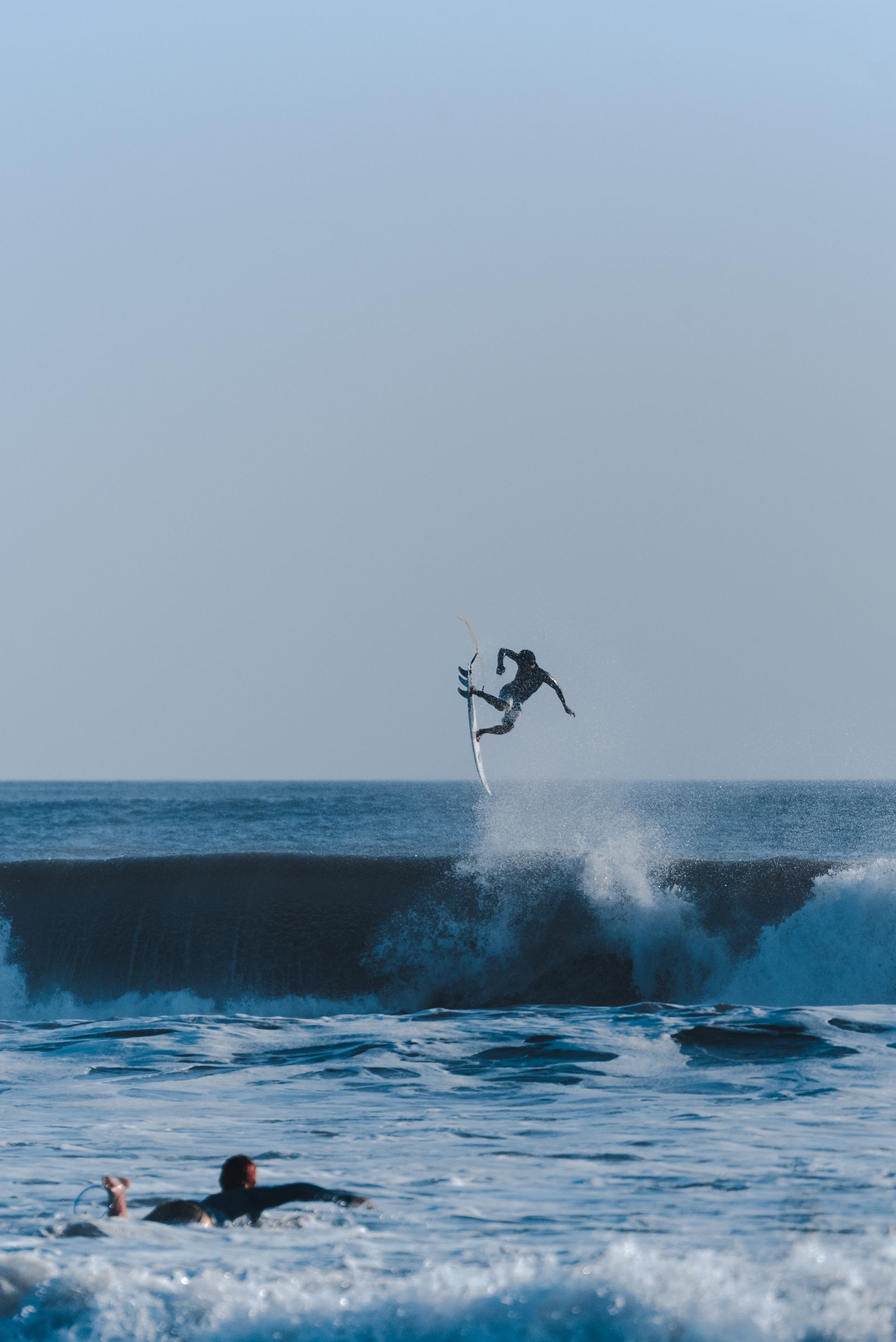 A surfer surfing through the waves in Thailand.