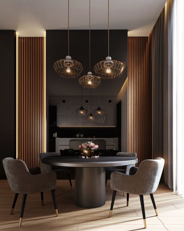 Modern dining room with a dark round table, grey chairs, and three textured pendant lights before a wood-slatted wall.
