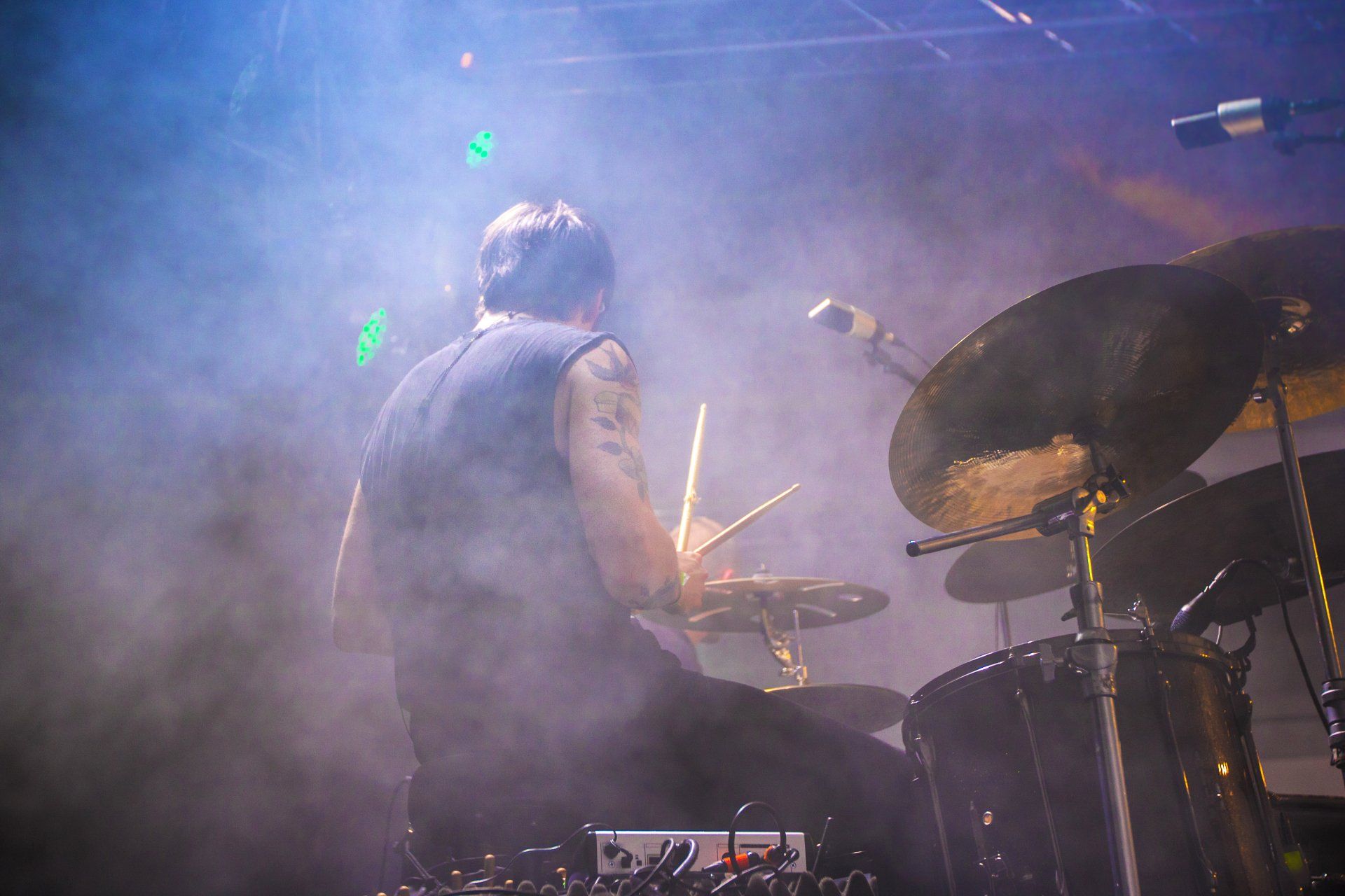 a man is playing drums on a stage in front of a microphone .