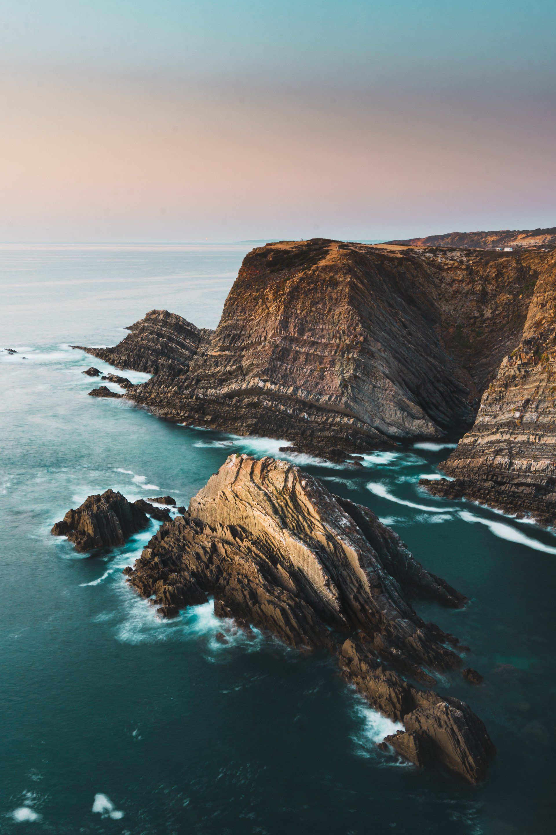 An aerial view of a rocky cliff overlooking the ocean.