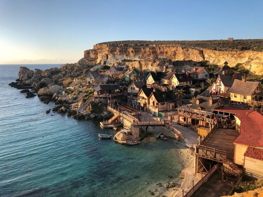 An aerial view of a small village on a cliff overlooking the ocean.