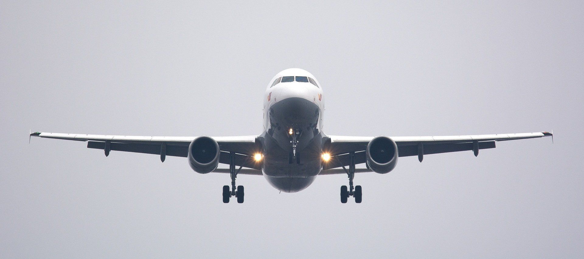A large passenger jet is flying through a cloudy sky.