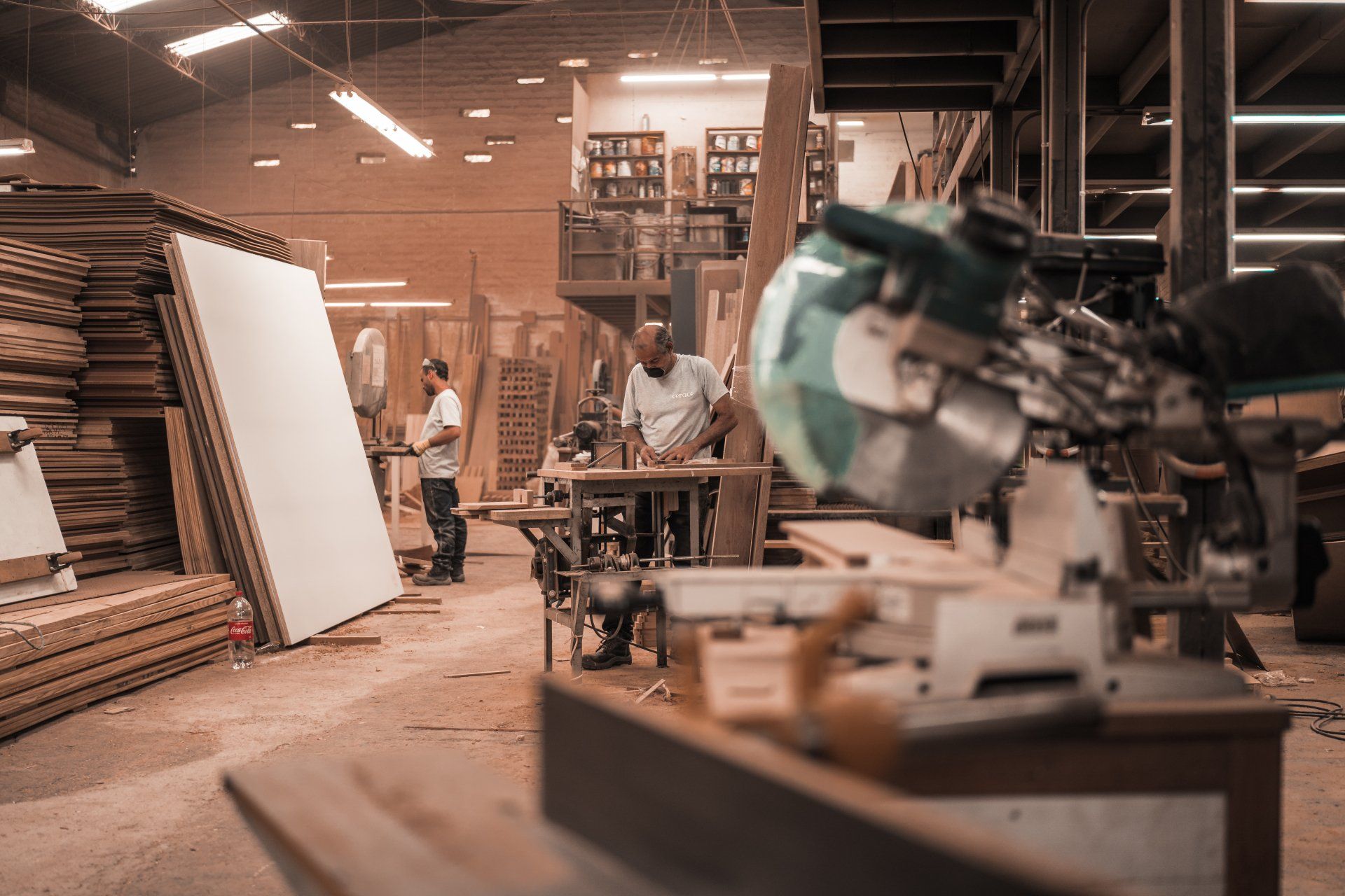 A man is using a circular saw in a woodworking shop.