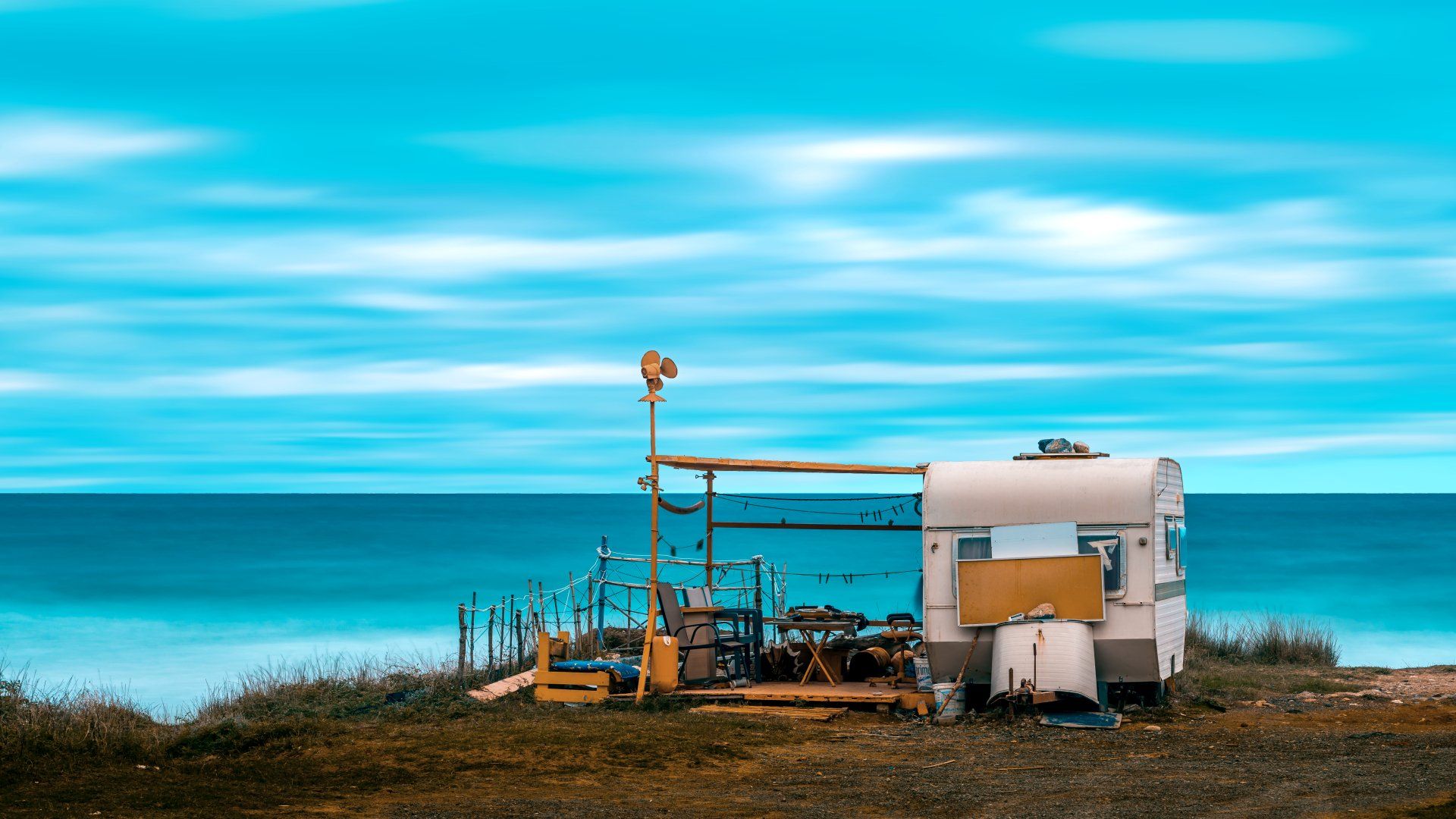 Un camper è parcheggiato su una collina vicino all'oceano.