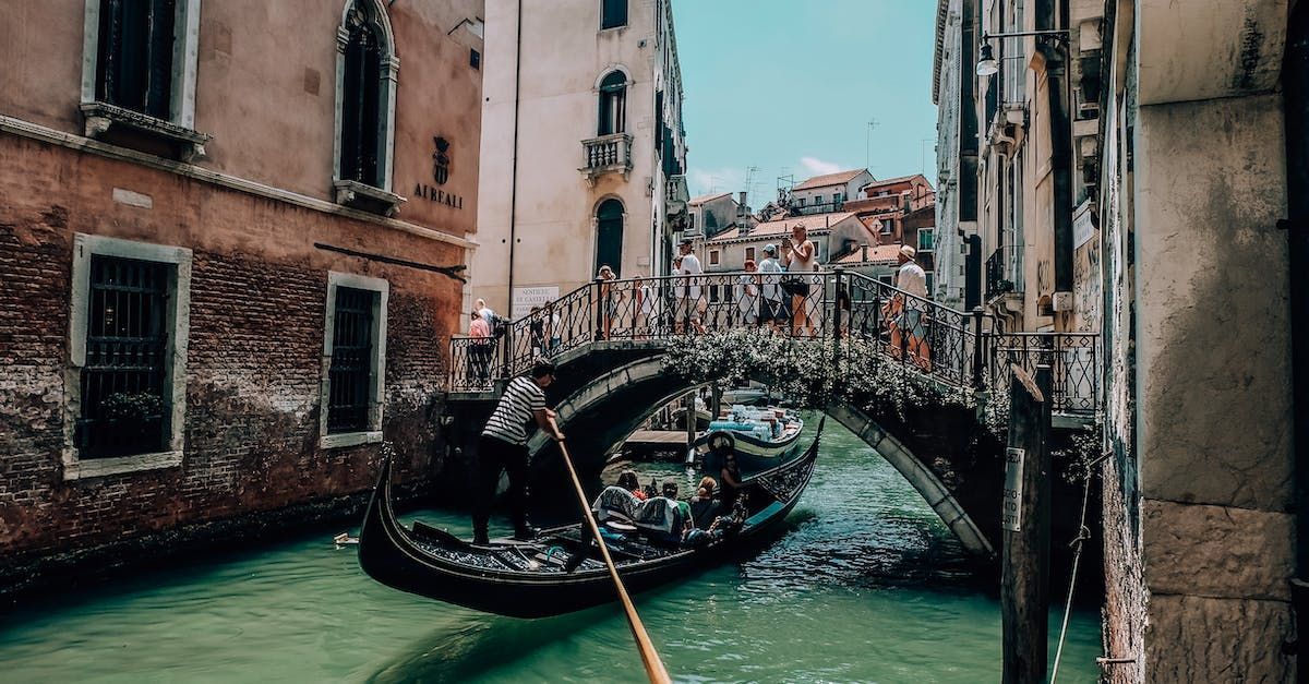 Gondolier skillfully rowing a gondola through a serene Venetian canal
