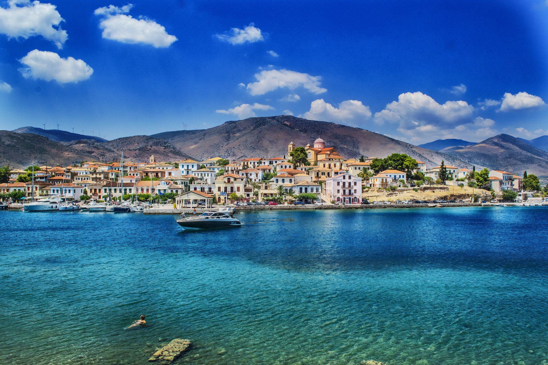A small town is sitting on the shore of a large body of water.