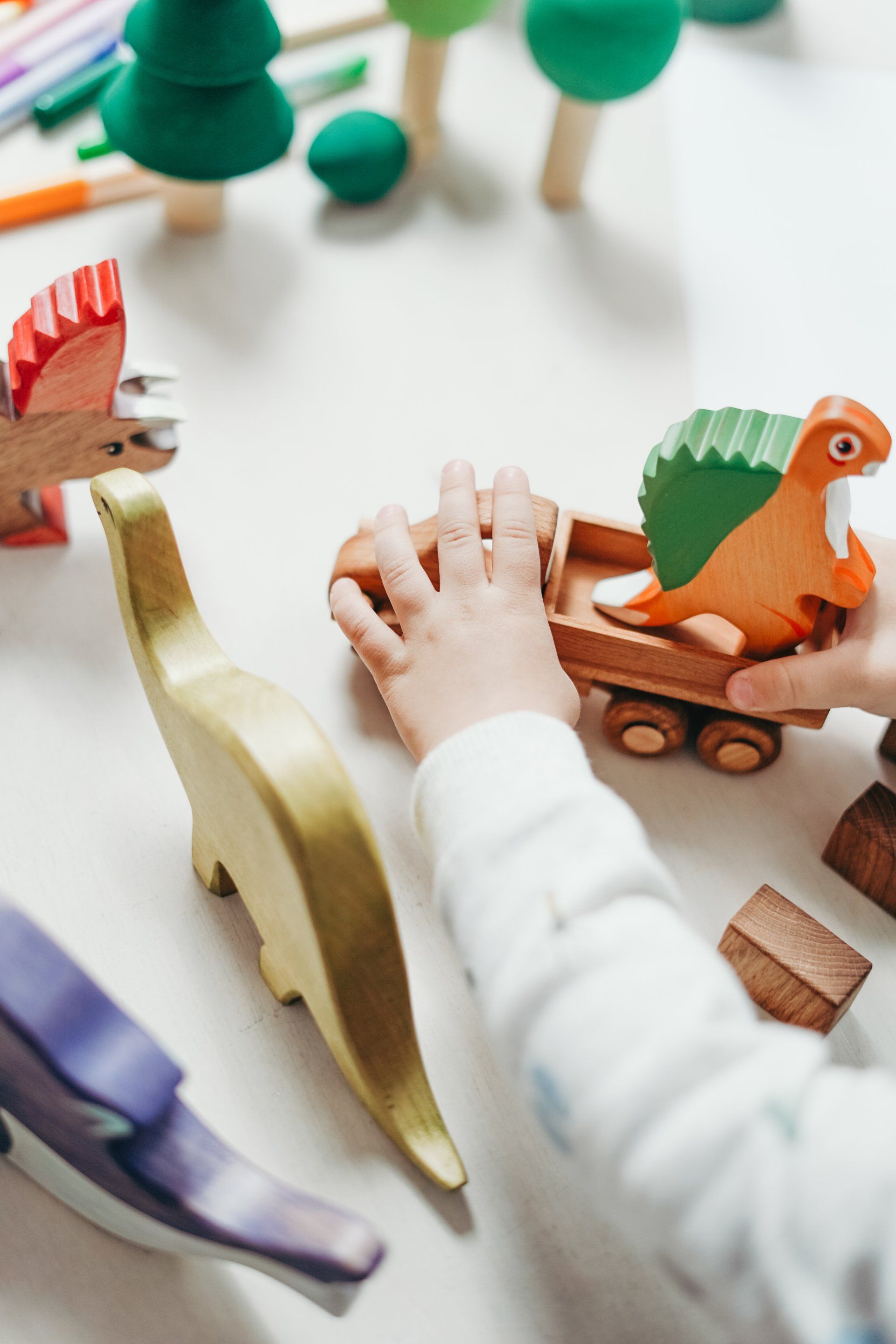 A baby is playing with wooden toys on a table.