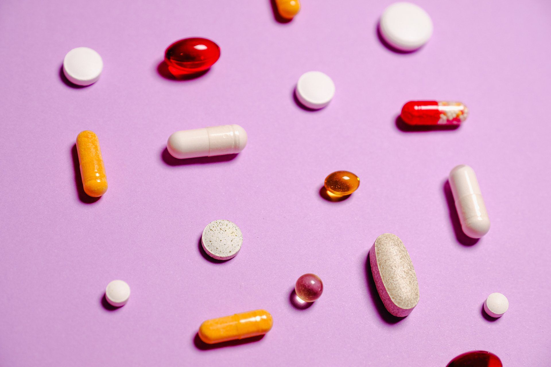 There are many different types of pills on a purple background.