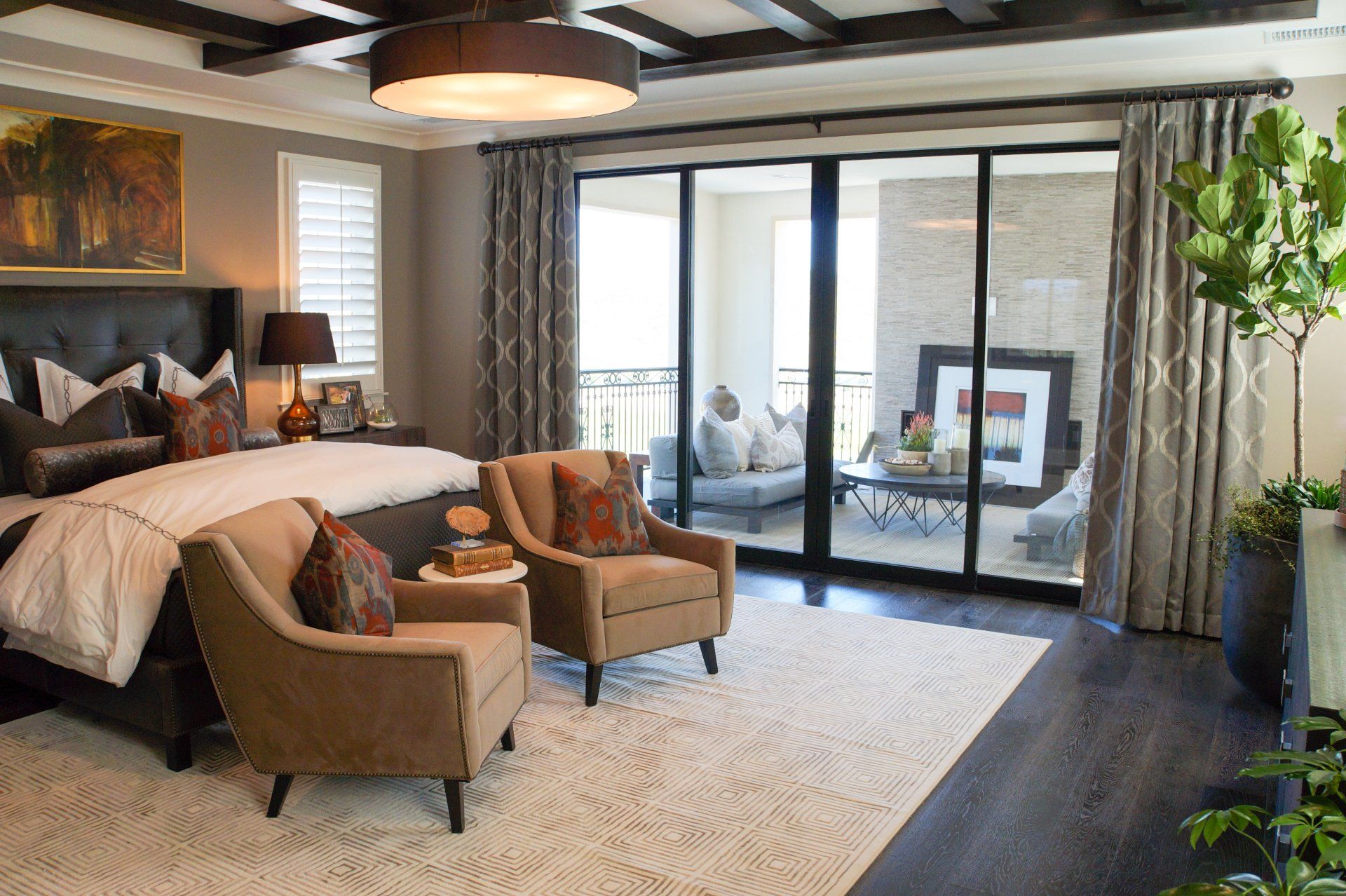 A bedroom with a large bed , chairs and sliding glass doors.