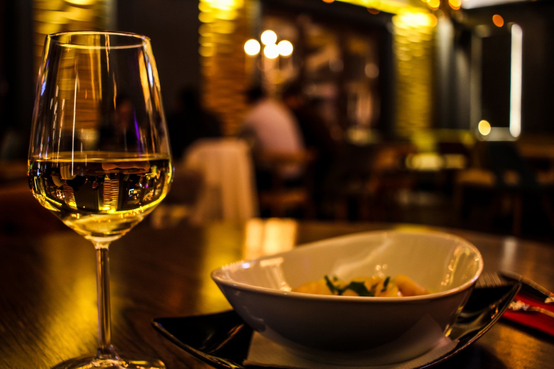 un primo e un bicchiere di vino sul tavolo di un ristorante.