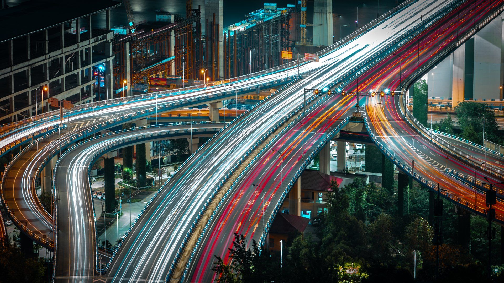 A long exposure photo of a highway intersection at night.