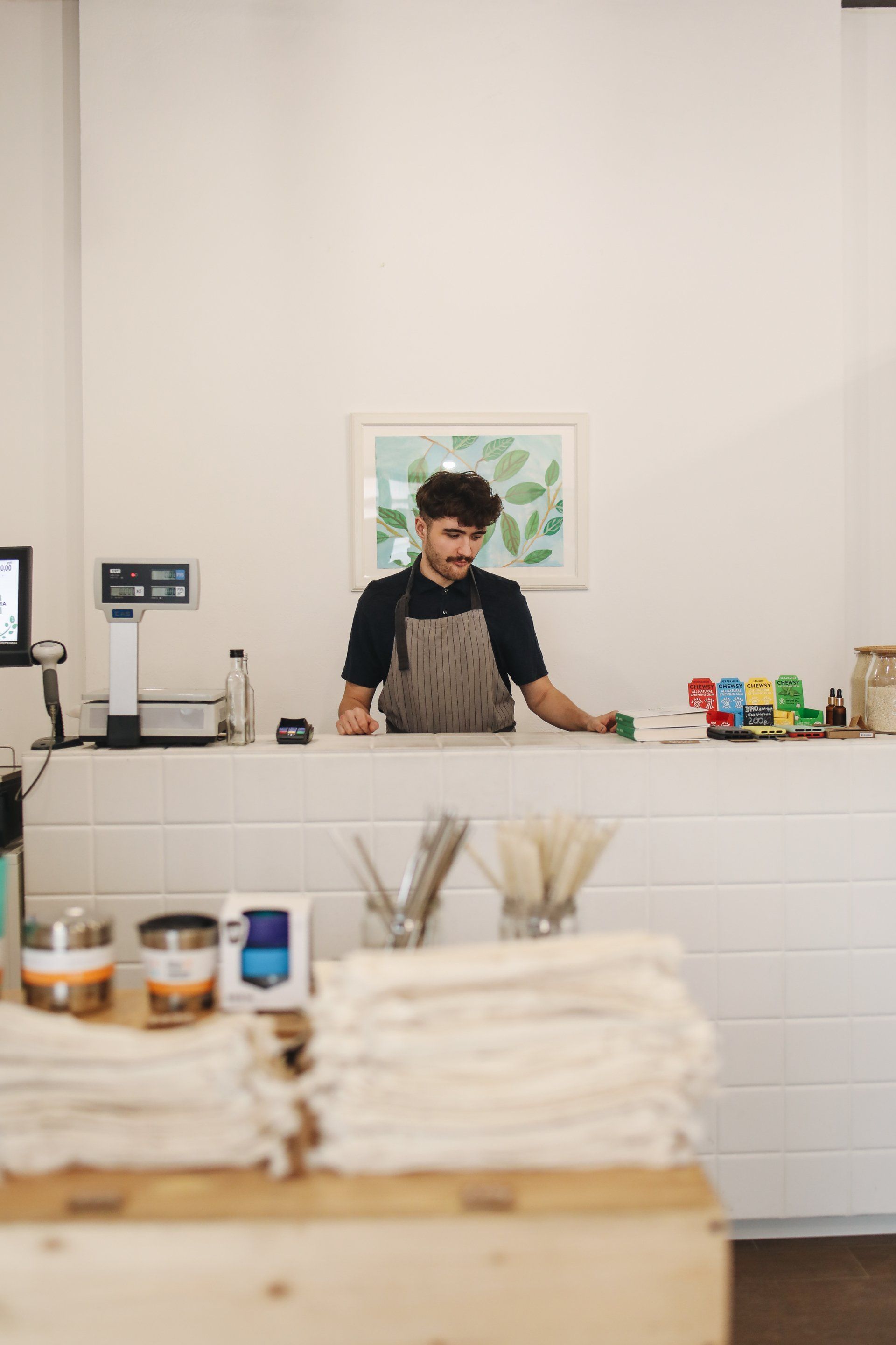 A man is standing behind a counter in a store.