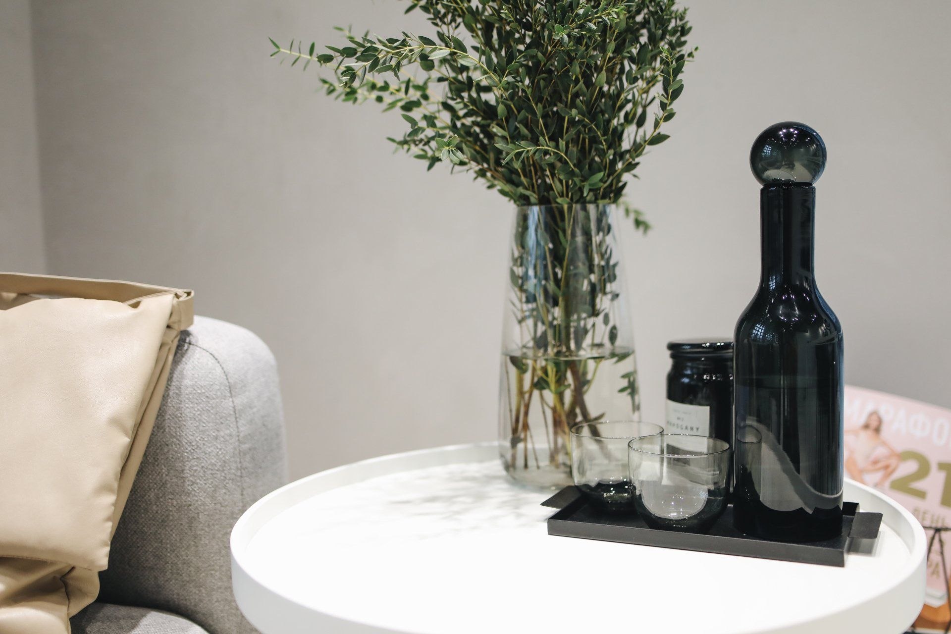 uma mesa com um vaso de flores e uma garrafa