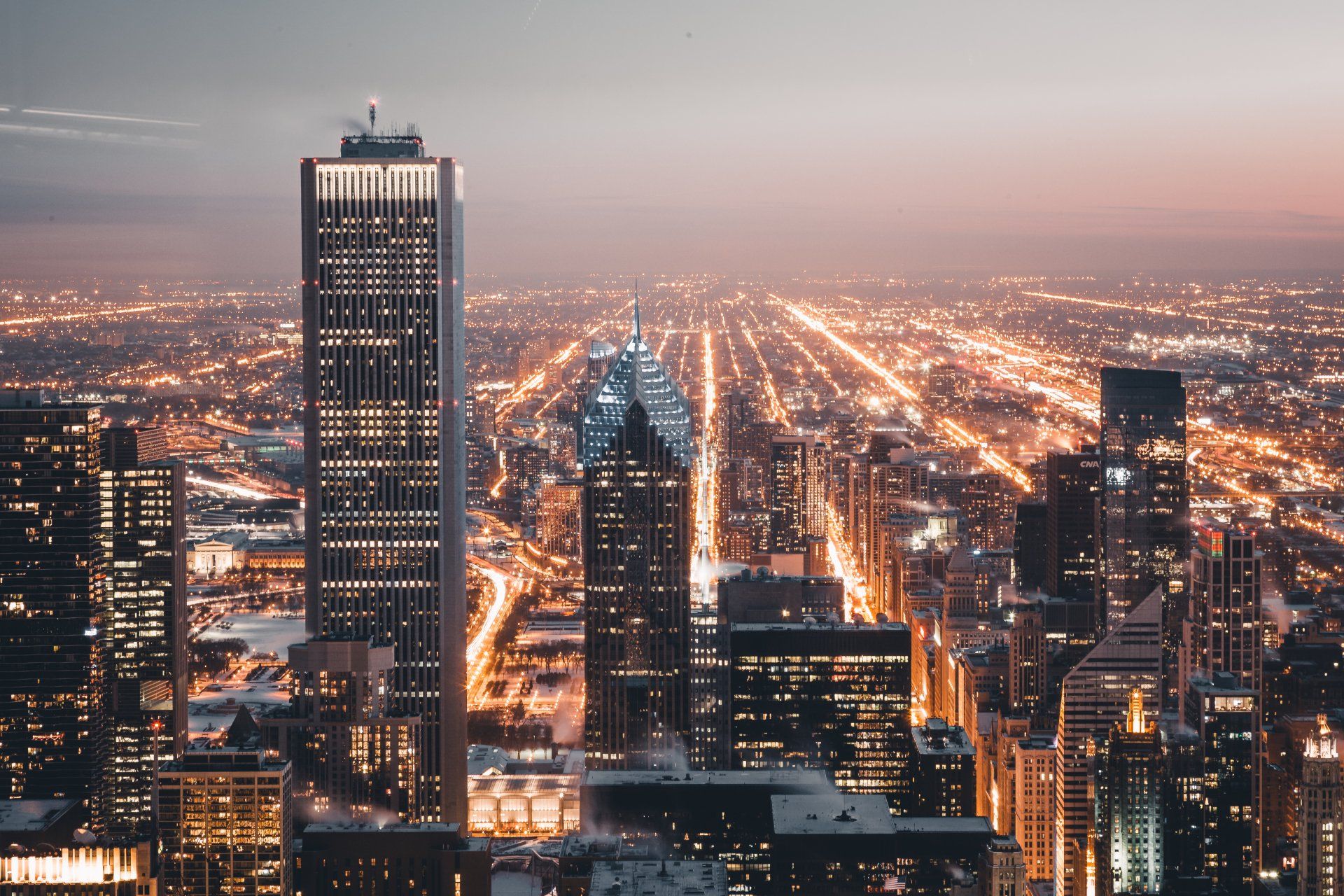 An aerial view of a city at night with lots of tall buildings