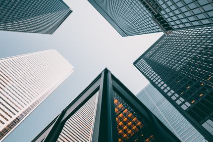 View from below of modern skyscrapers against a clear, blue sky.