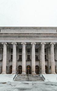 A large building with columns and stairs in front of it.