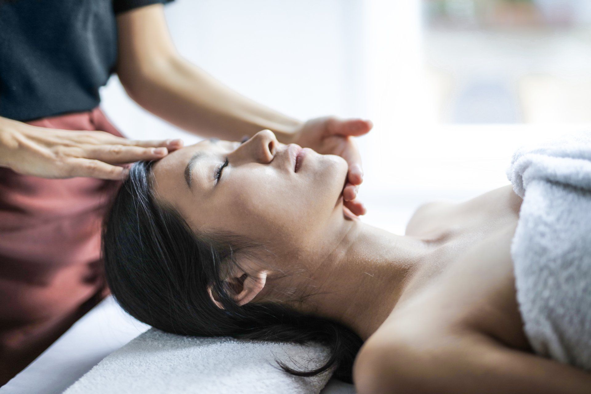 Massage therapist performing traditional Hawaiian Lomi Lomi massage in Haiku, Maui