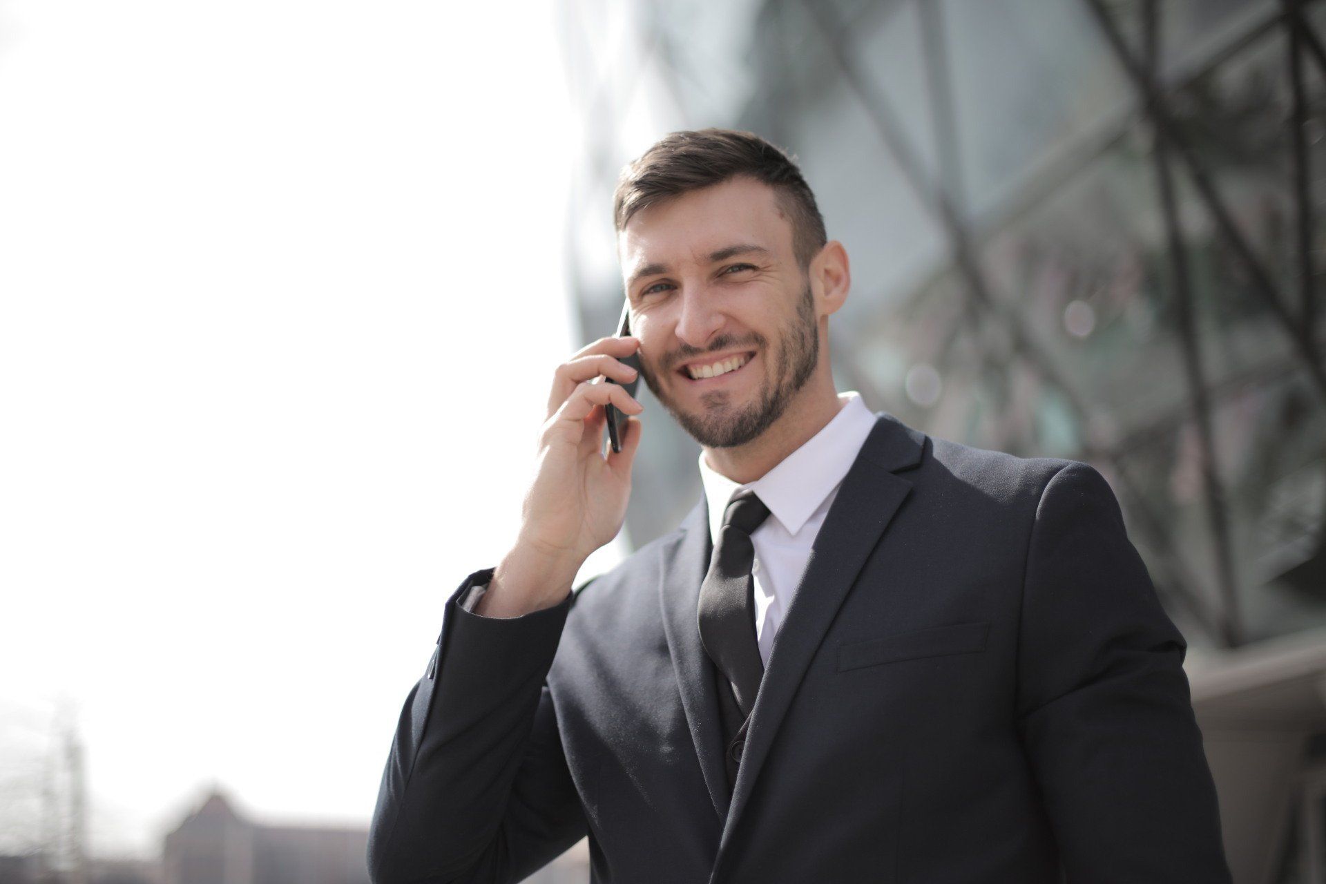 A man in a suit and tie is talking on a cell phone.