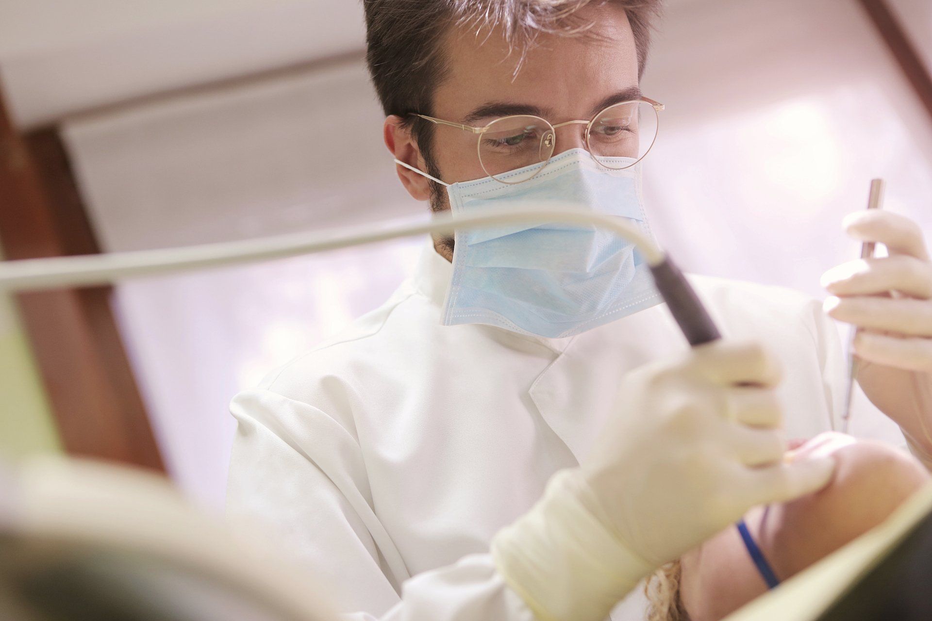 Dentist in full gear holding equipment.