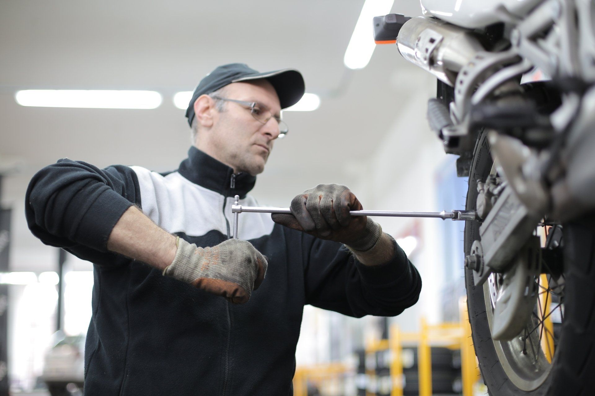 Mechanic replacing a tyre on an elevated car