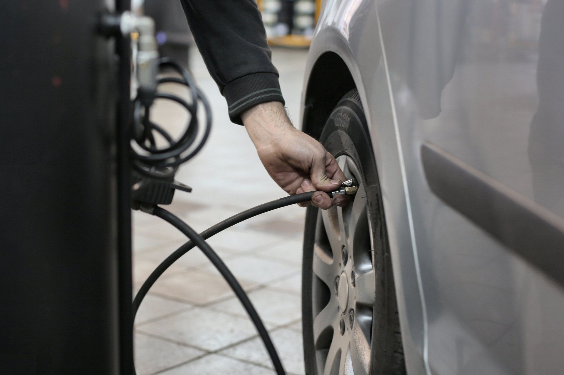 a person is pumping air into a car tire .