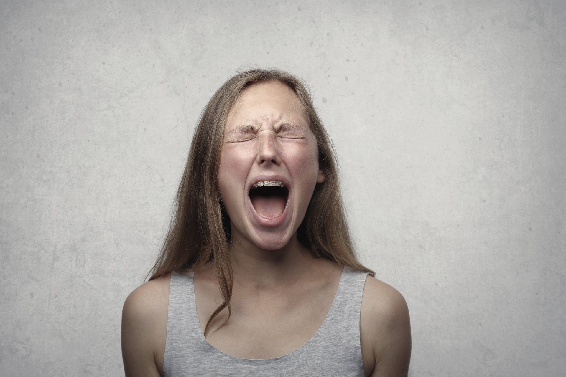 A young woman is screaming with her mouth open.