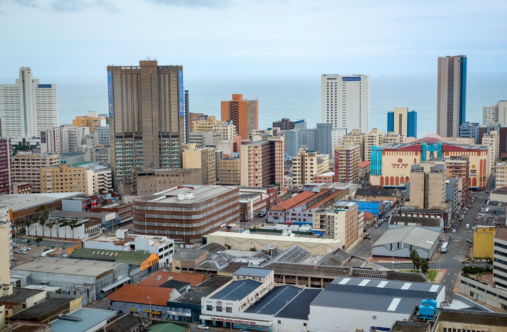 An aerial view of a city with lots of buildings and a cloudy sky.