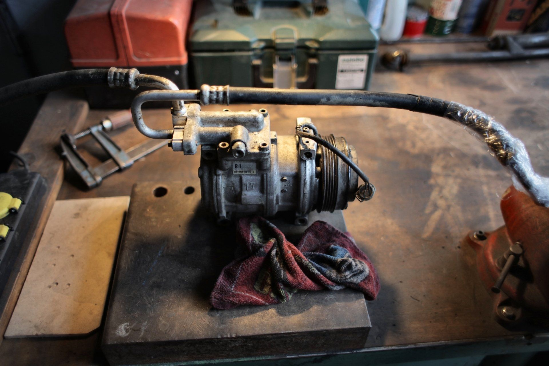 A compressor is sitting on a table next to a hose