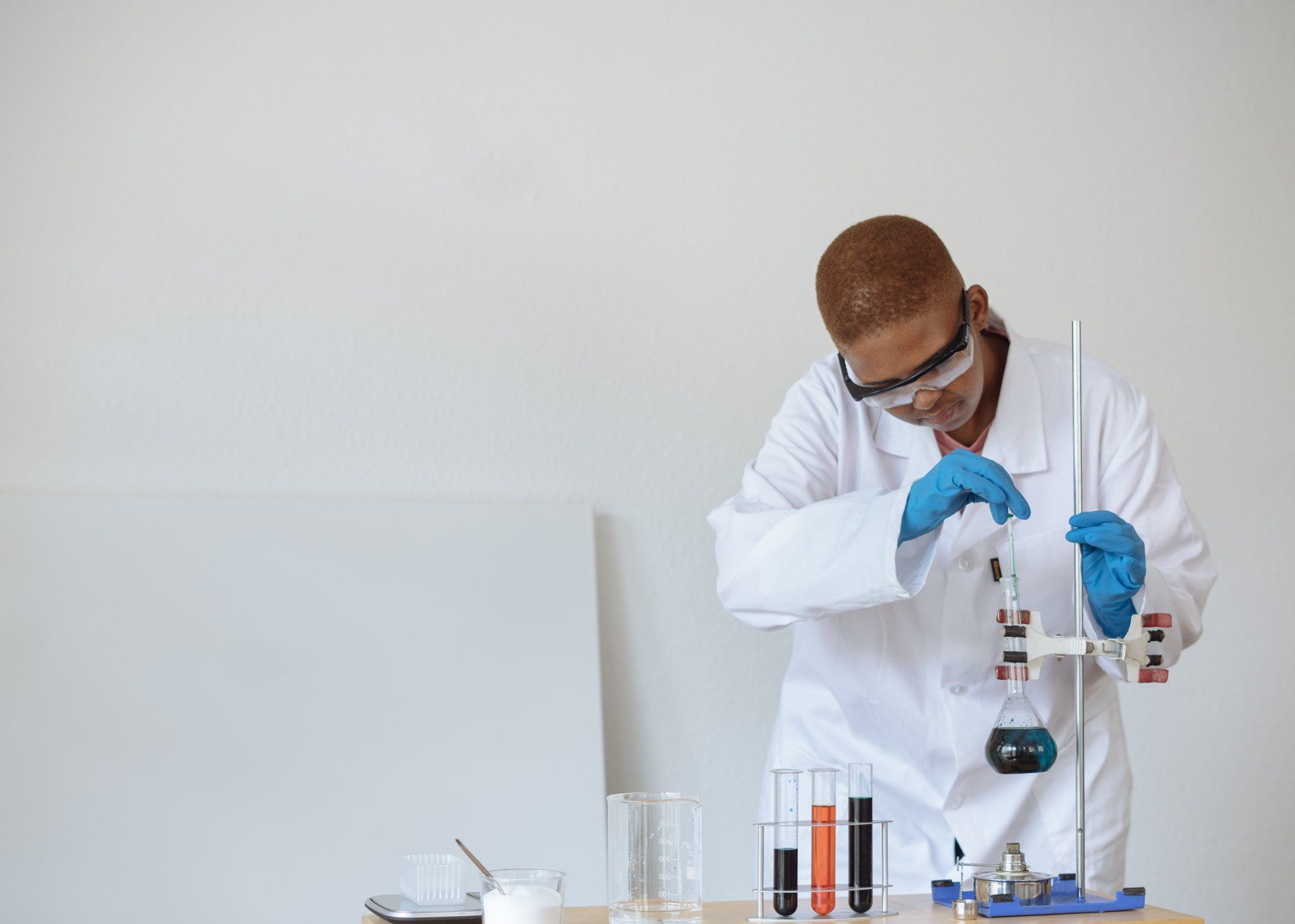 A scientist is pouring liquid into a beaker in a laboratory.