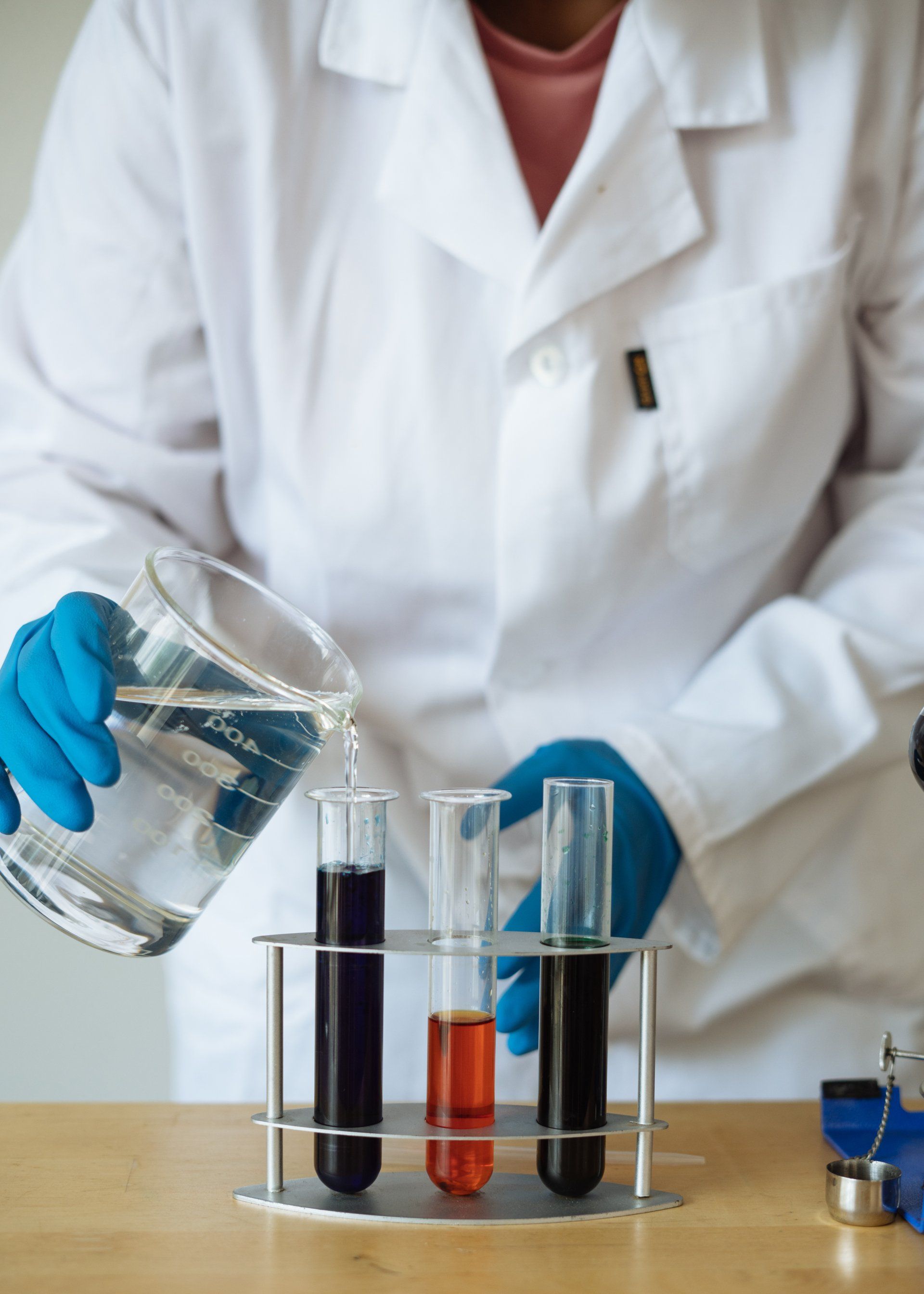 A scientist is pouring liquid into test tubes.