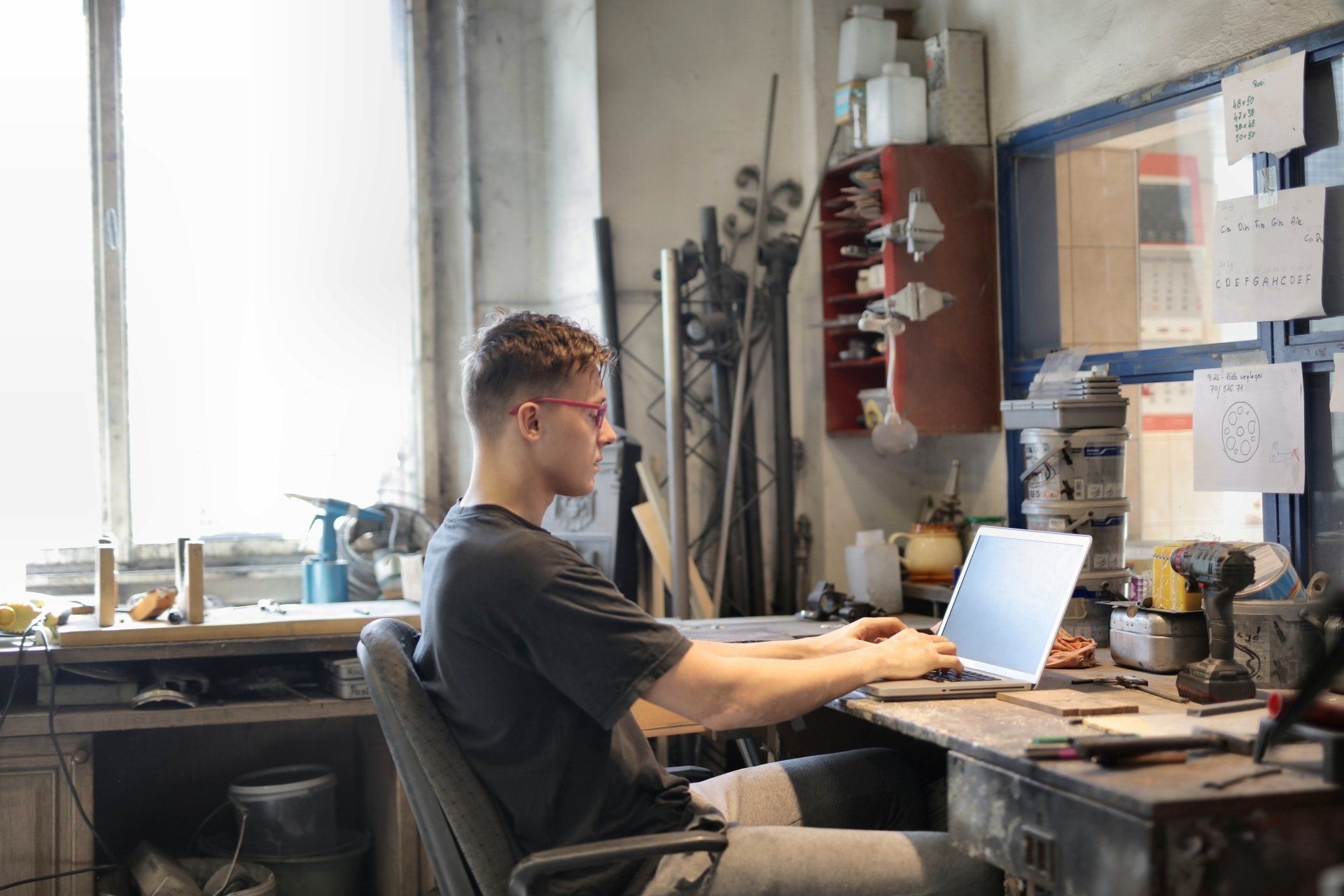 een man zit aan een bureau en gebruikt een laptopcomputer.