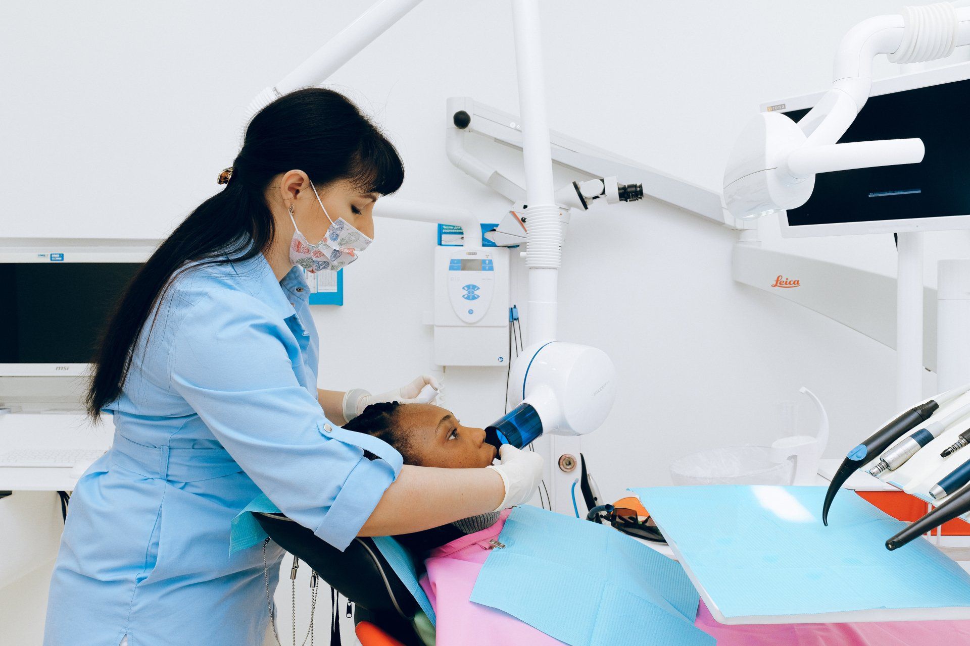 Dentist taking an X-ray of a patient's mouth in a dental office.