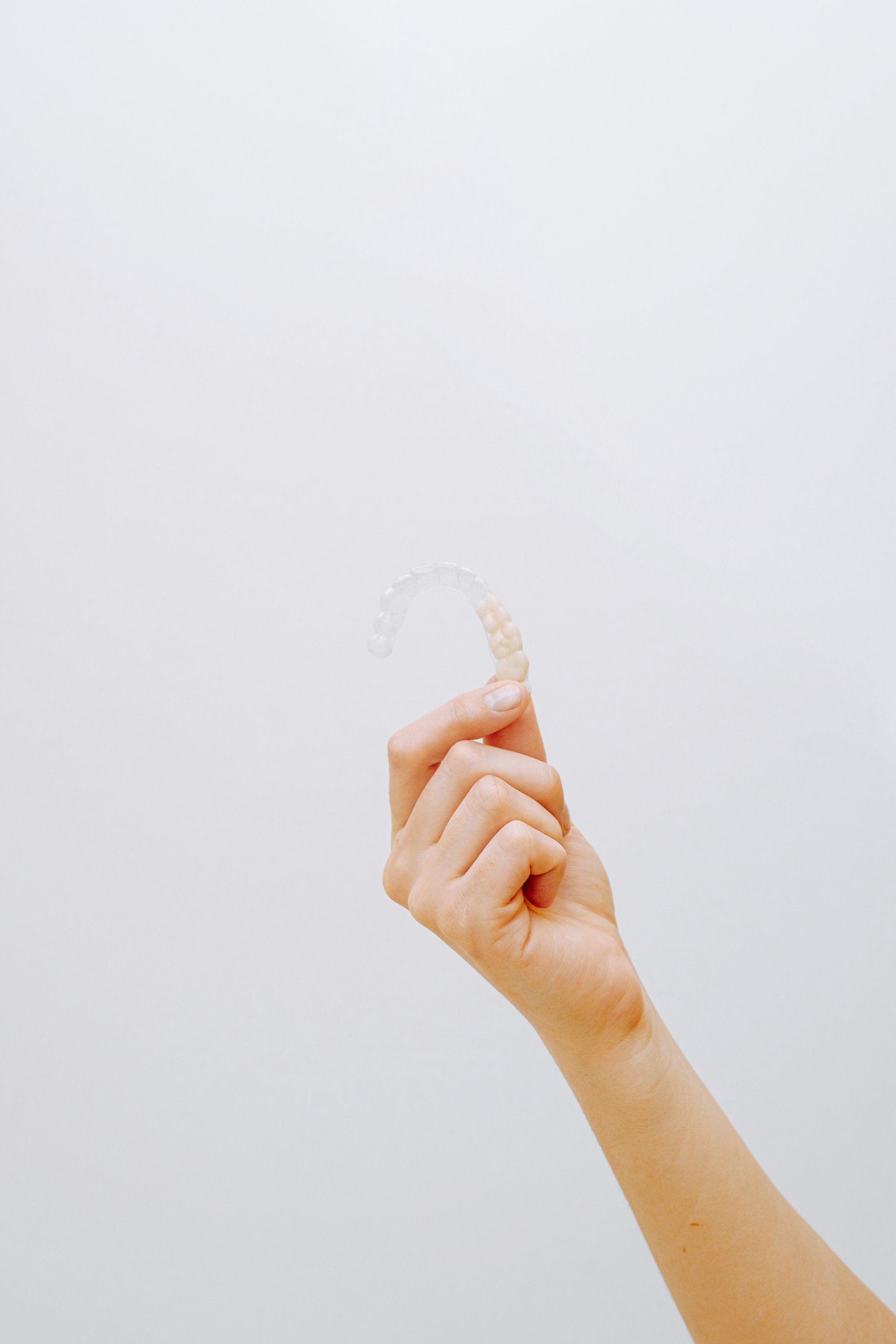 a person is holding a clear brace in their hand .